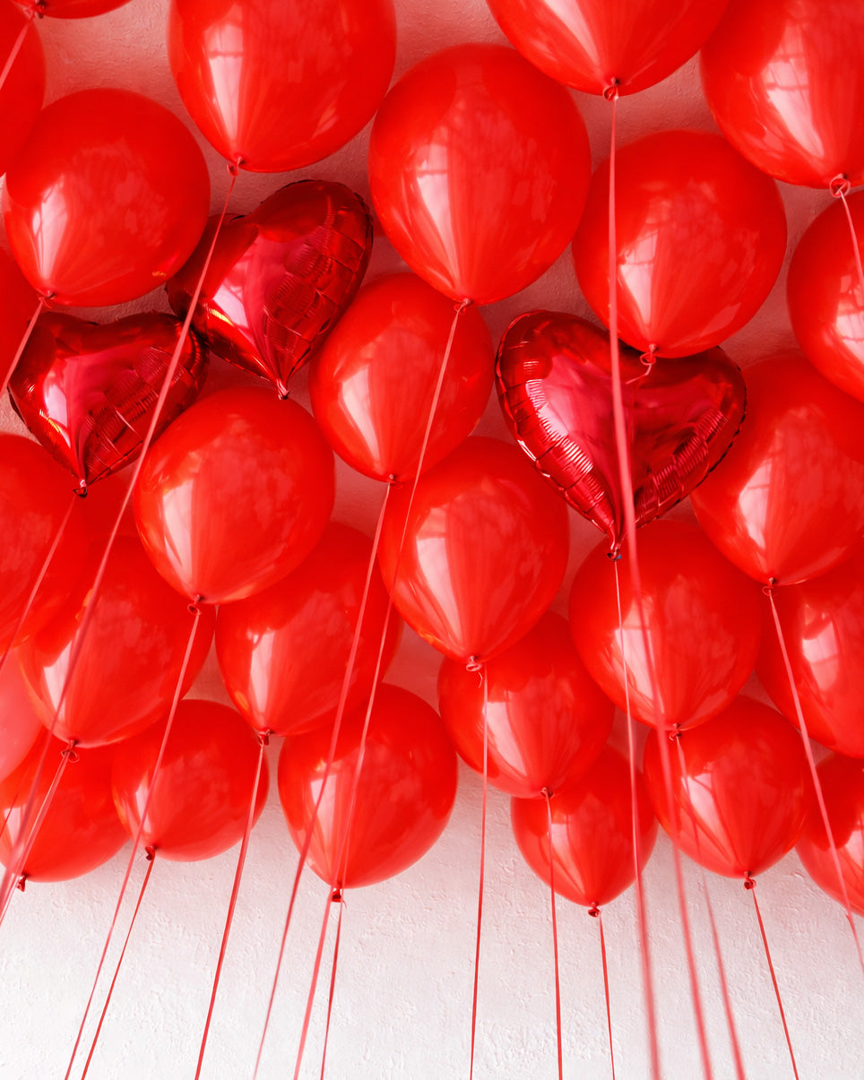 Red balloons with heart shapes on a white background