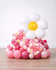 Balloon arrangement shaped like a daisy with 'Happy Valentine's Day' hearts on a white background